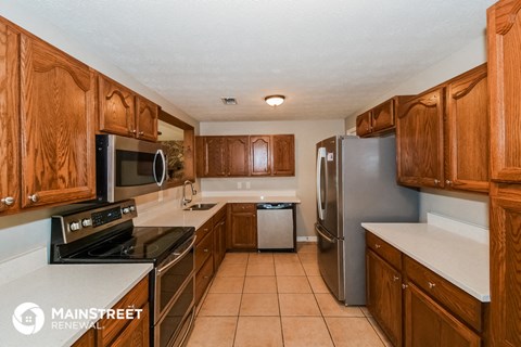 a kitchen with wooden cabinets and stainless steel appliances