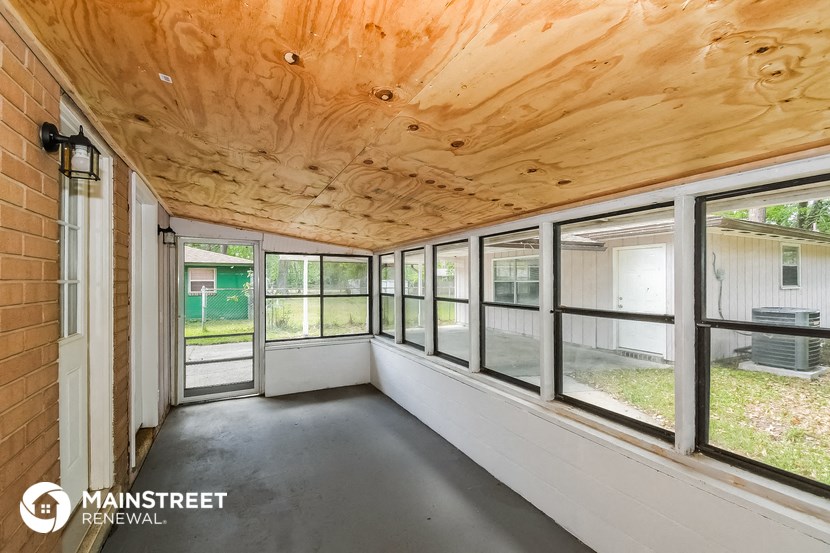 the screened in porch has large windows and a wood ceiling