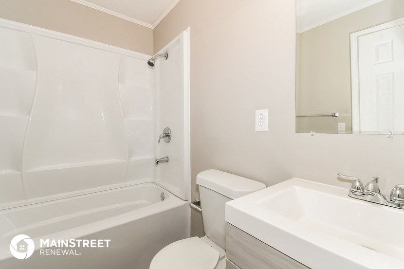 a white bathroom with a sink toilet and shower