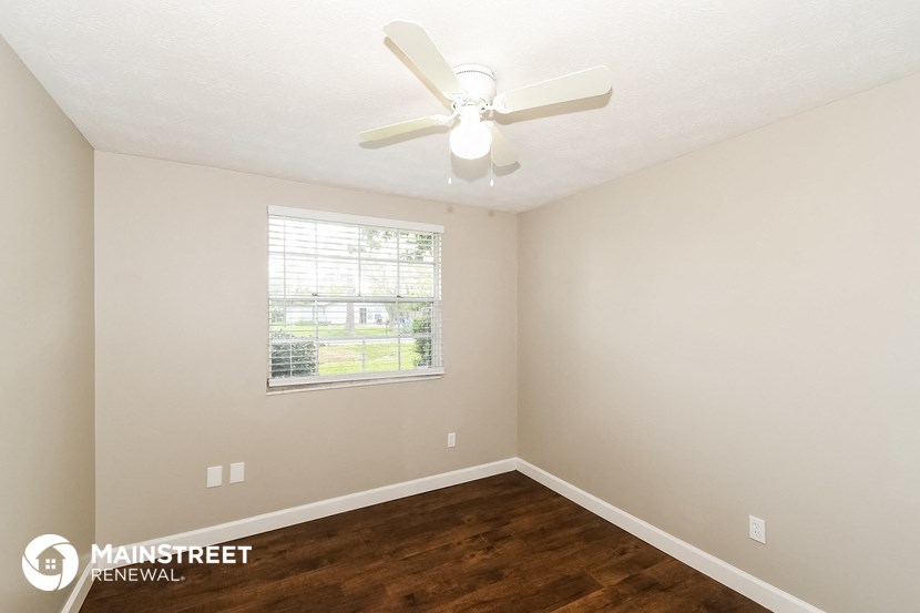 a bedroom with a ceiling fan and a window