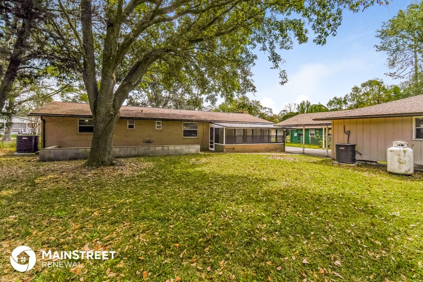 a backyard with a house and a large tree