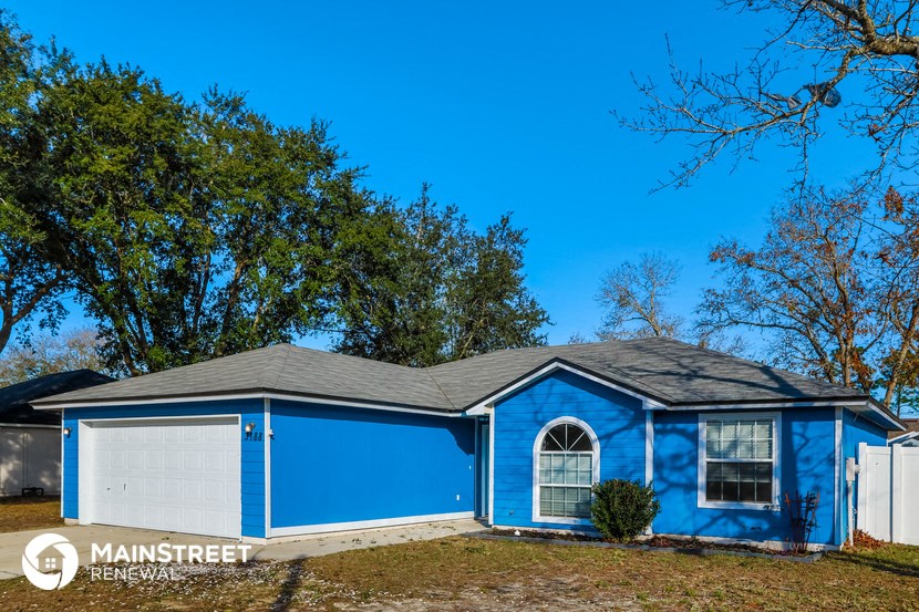 the front of a blue house with a white garage