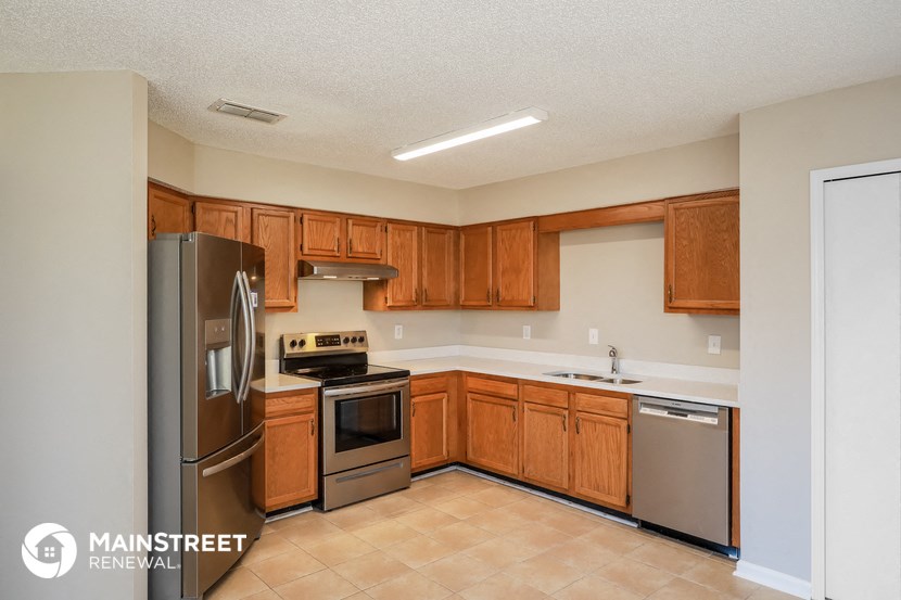 a kitchen with wooden cabinets and stainless steel appliances