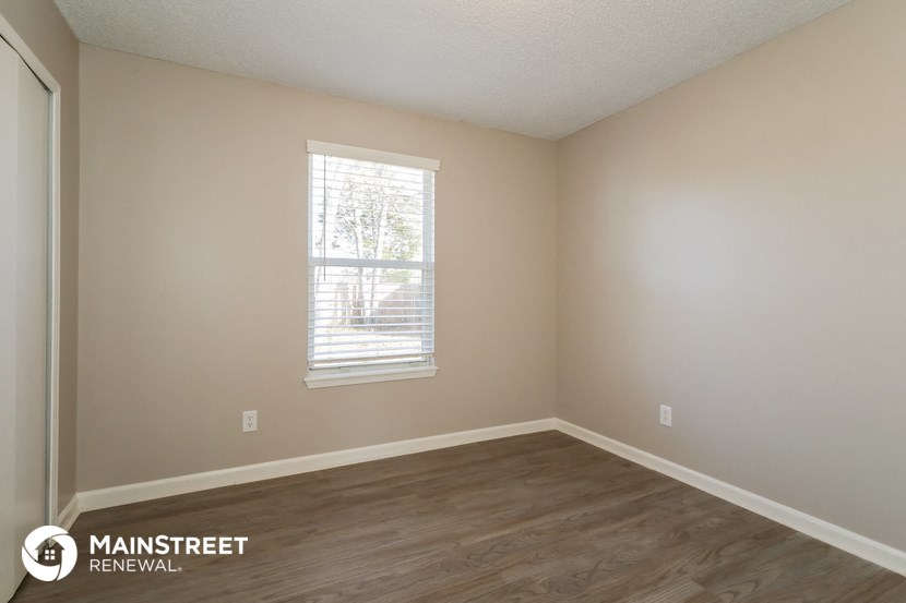 the interior of an empty room with wooden floors and a window