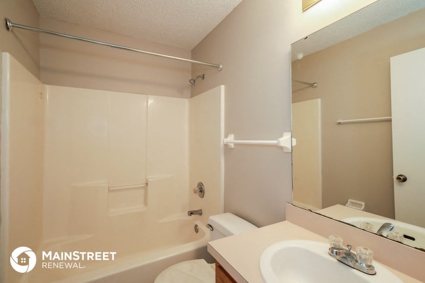 a bathroom with a shower and a sink and a toilet