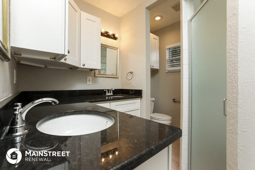 a black and white bathroom with a sink and a toilet
