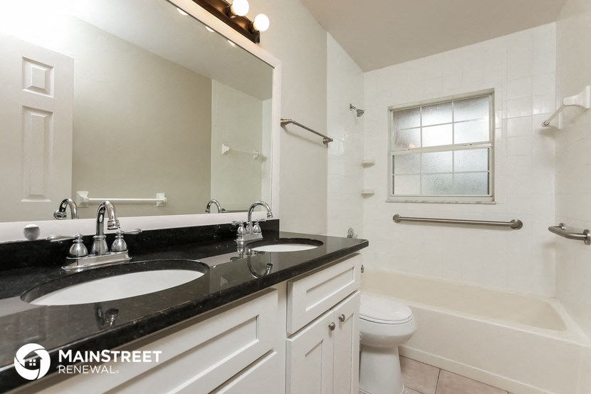 a bathroom with two sinks and a tub and a toilet