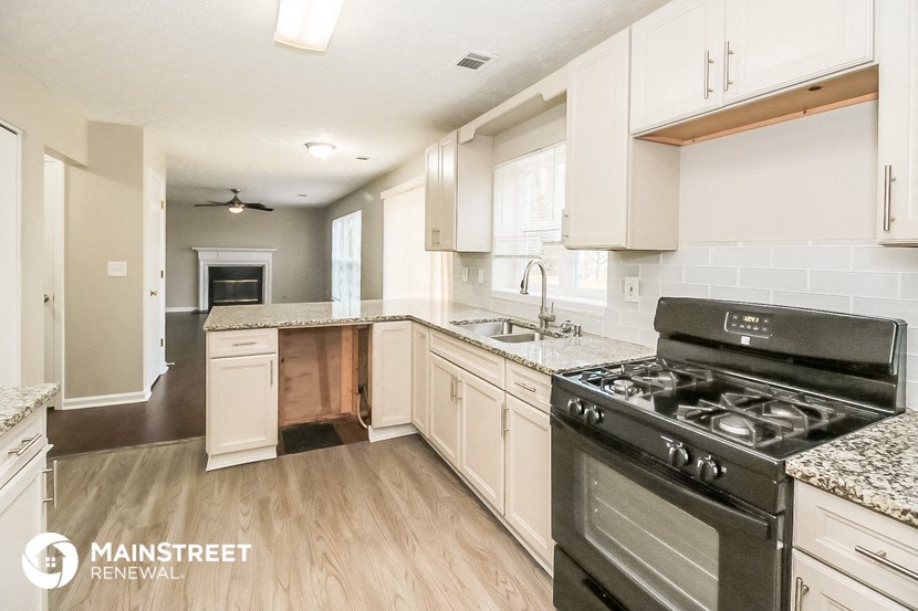 a kitchen with white cabinets and stainless steel appliances and a stove top oven