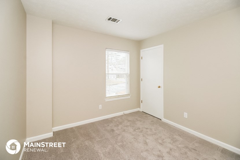 a bedroom with a carpeted floor and a window