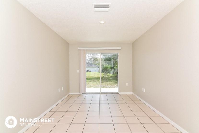 an empty living room with a sliding glass door to the yard