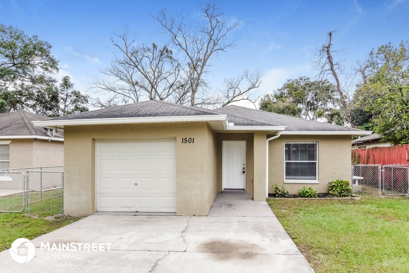 a home with a white garage door and a driveway