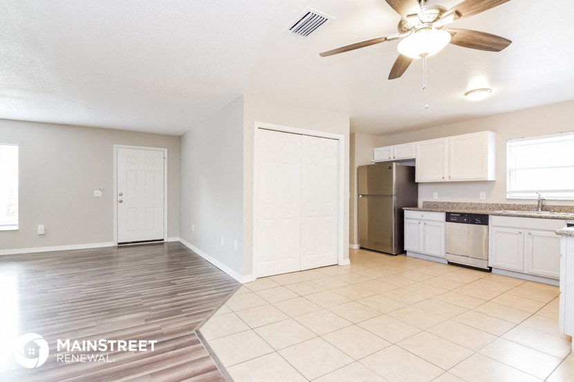 an open kitchen and living room with a ceiling fan