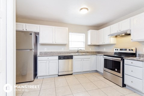 a kitchen with white cabinets and stainless steel appliances