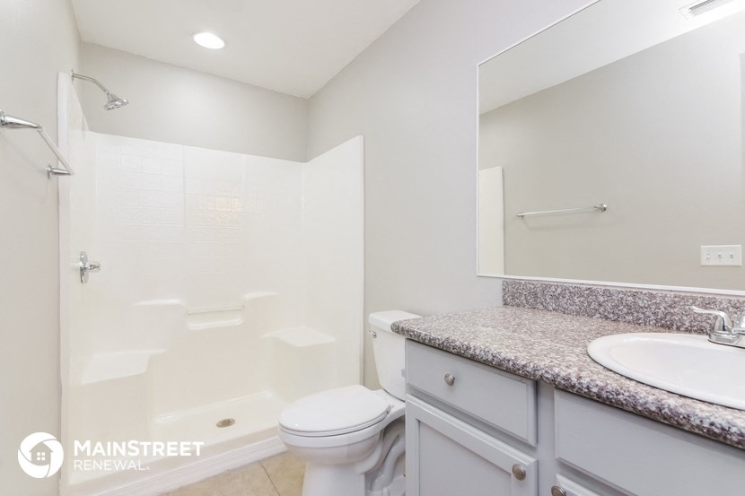 a bathroom with a shower toilet and sink and a mirror