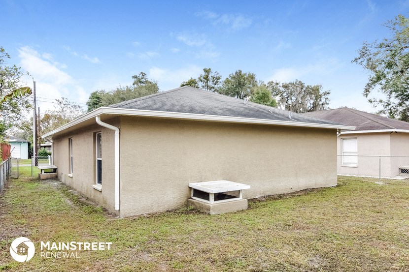 a small tan house with a white bench in front of it
