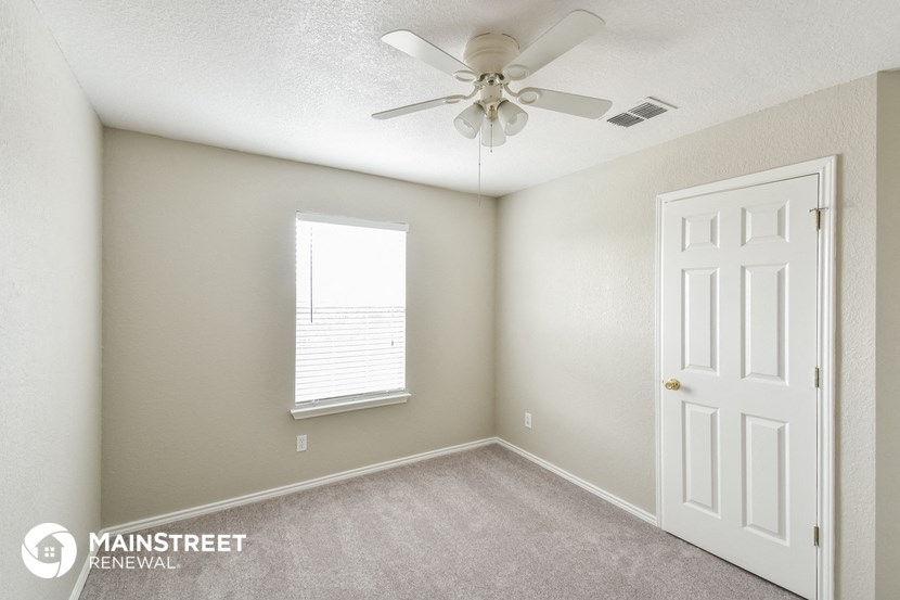 a bedroom with a ceiling fan and a window