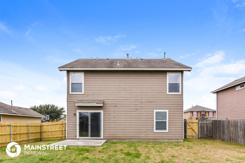 the back of a house with a fenced in yard