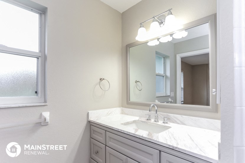 a bathroom with a sink and a mirror and a window