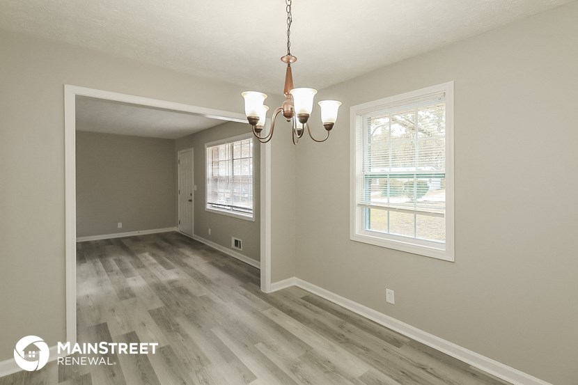 the living room of a house with a chandelier and a window