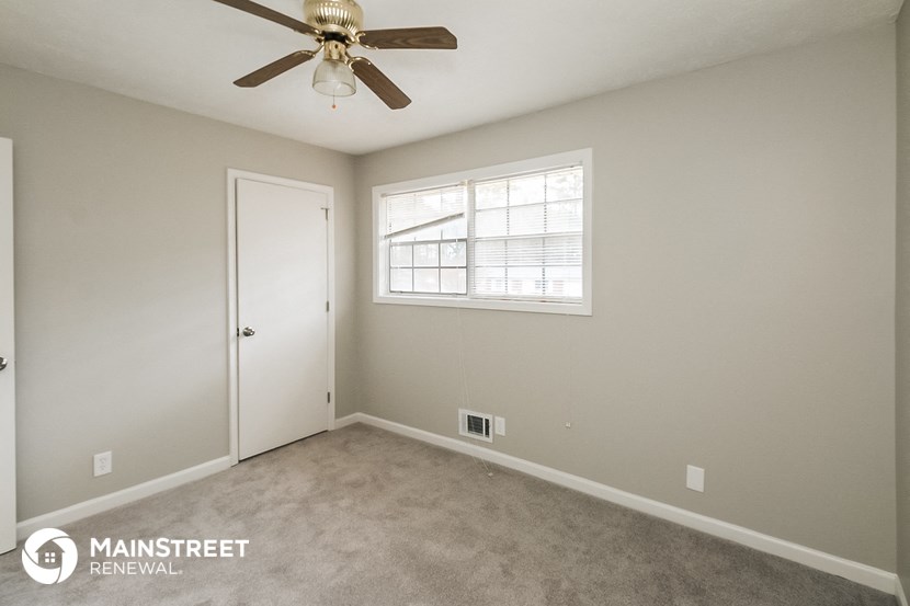 a bedroom with a ceiling fan and a white door