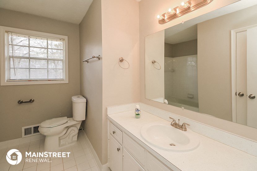 the bathroom has a large mirror and a white sink