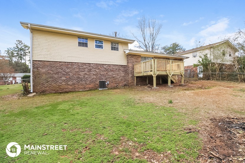 the back of a house with a yard and a deck