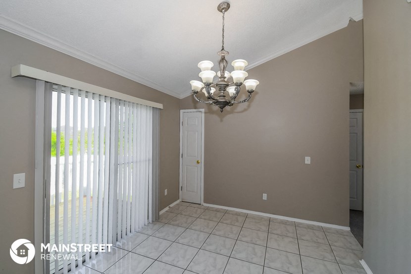 a dining room with a sliding glass door and a chandelier