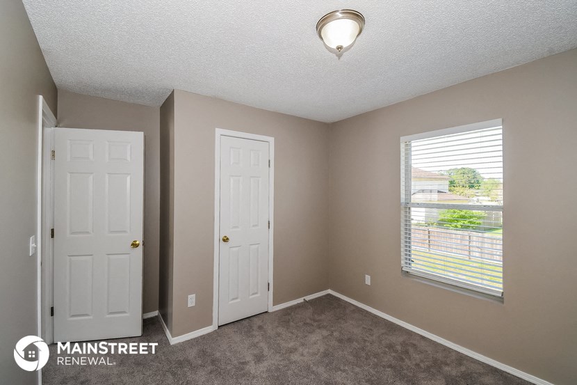the interior of a bedroom with two doors and a window