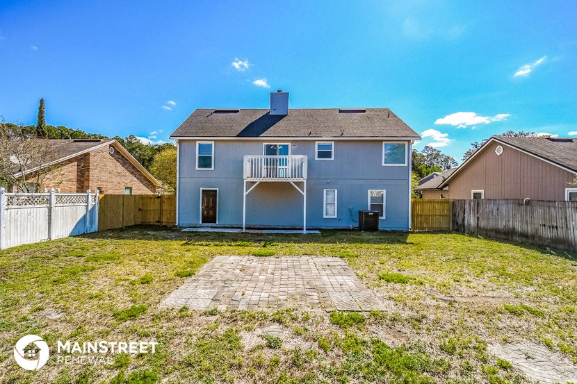 a blue house with a backyard and a deck