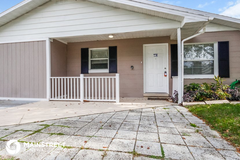 the front of a house with a porch and a white door
