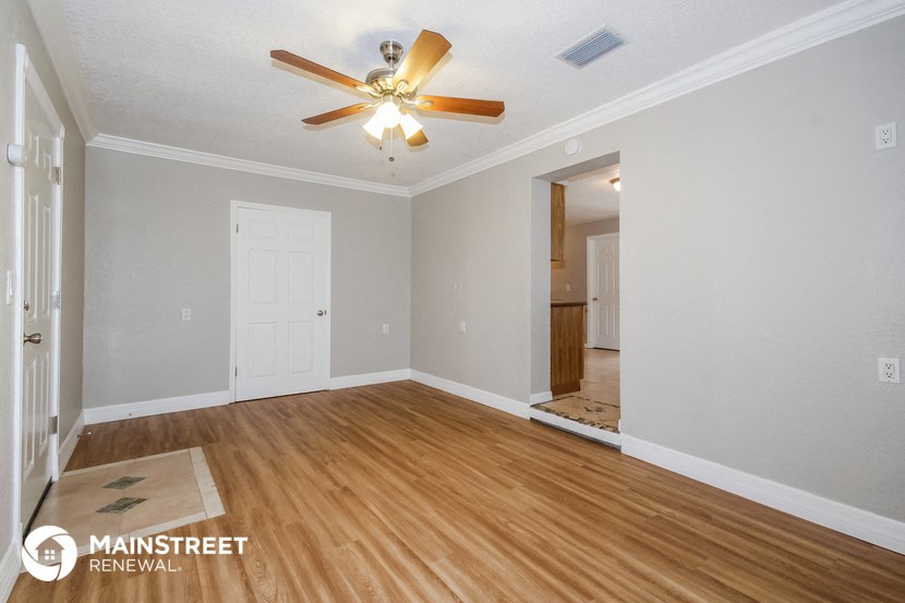 the living room and dining room with hardwood flooring and a ceiling fan
