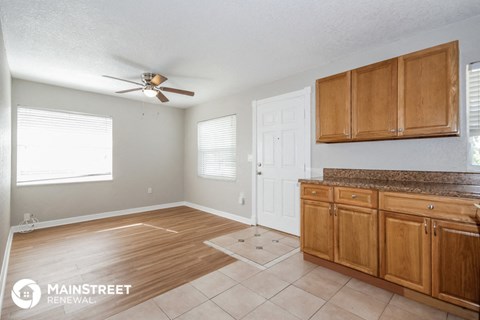 a kitchen with wooden cabinets and a ceiling fan