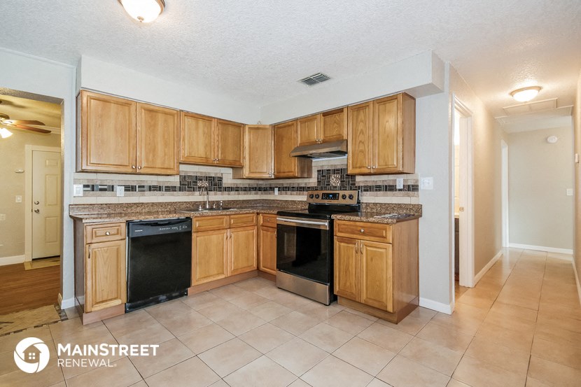 a kitchen with wooden cabinets and black appliances