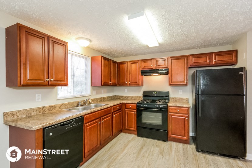 a kitchen with wooden cabinets and black appliances