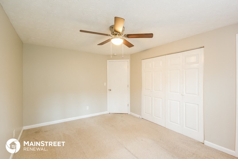 a bedroom with a ceiling fan and a closet