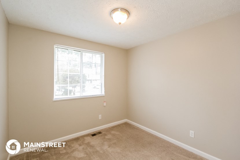 the interior of a small room with a window and carpet