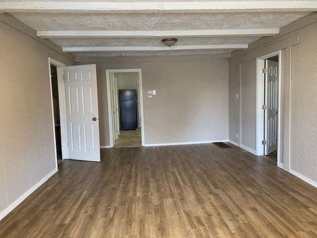 an empty living room with a wood floor