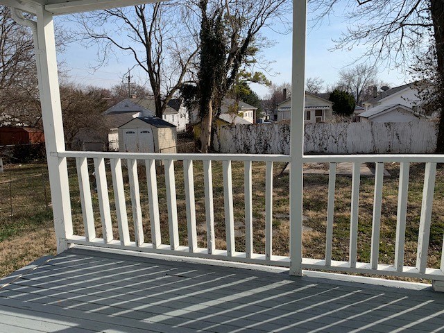 a porch with a view of a yard and houses