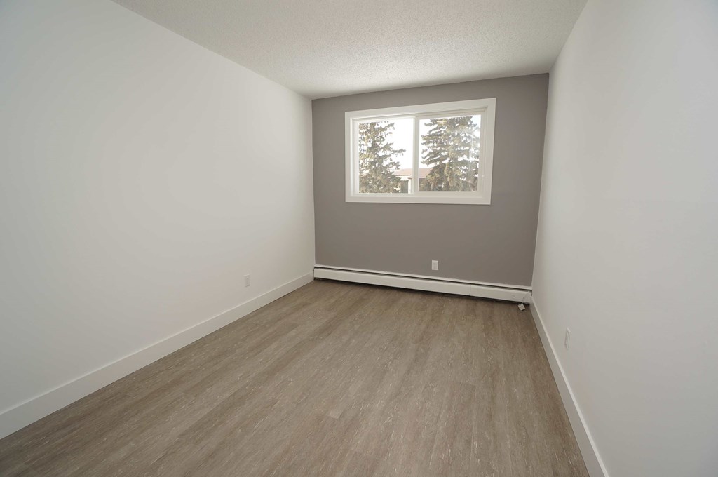 an empty room with white walls and a window