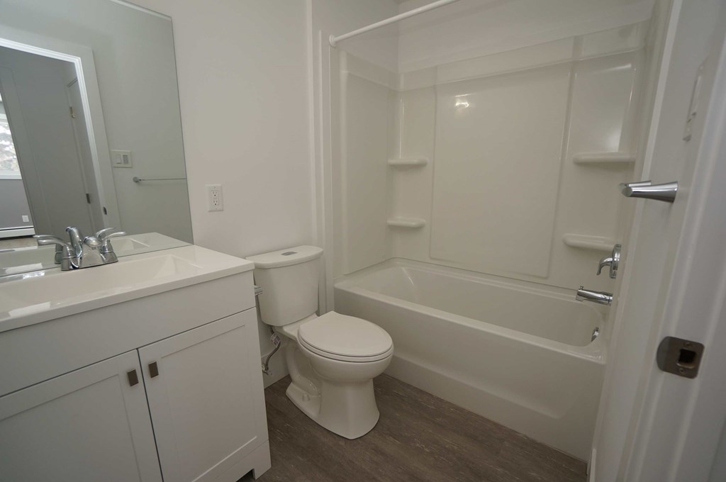 a bathroom with a toilet and a tub and a sink