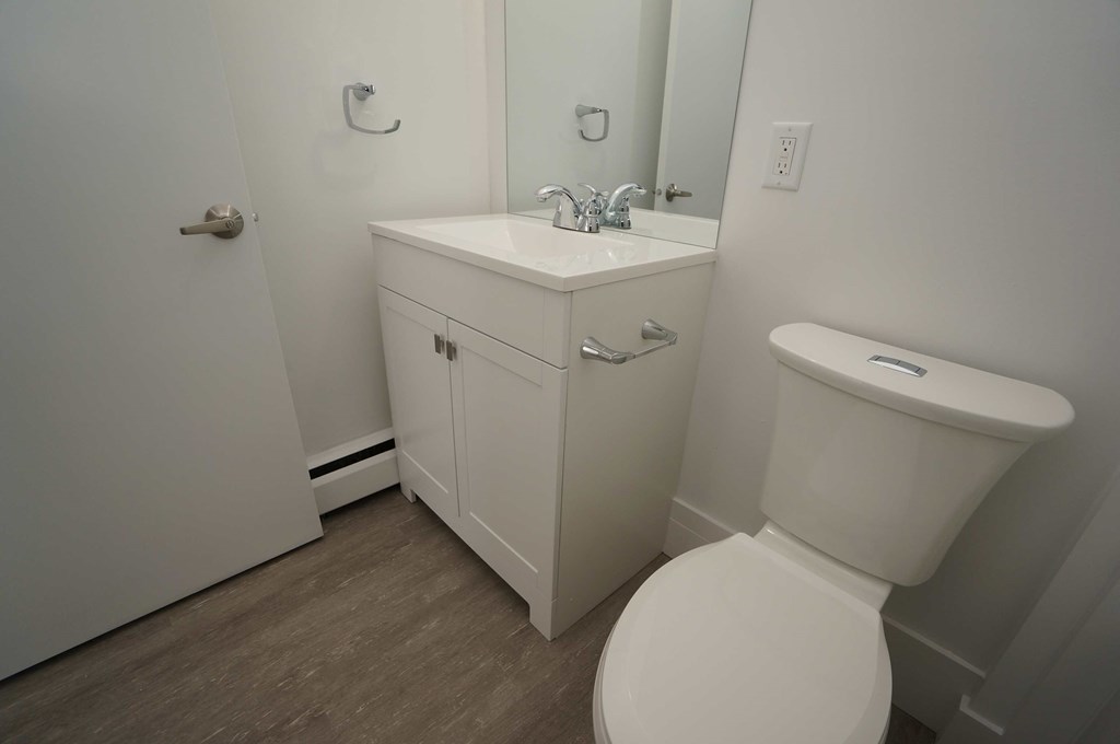 a bathroom with a toilet sink and mirror