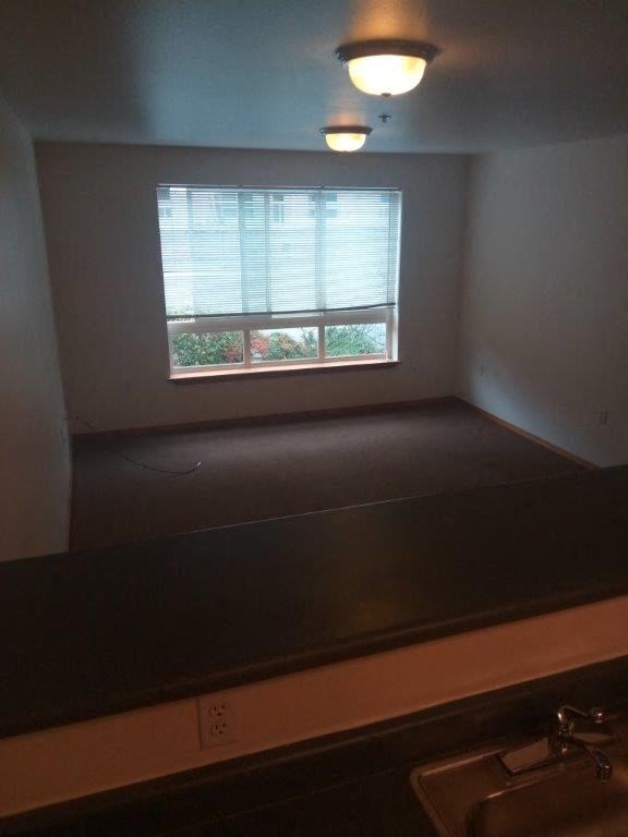 an empty room with a window and a sink