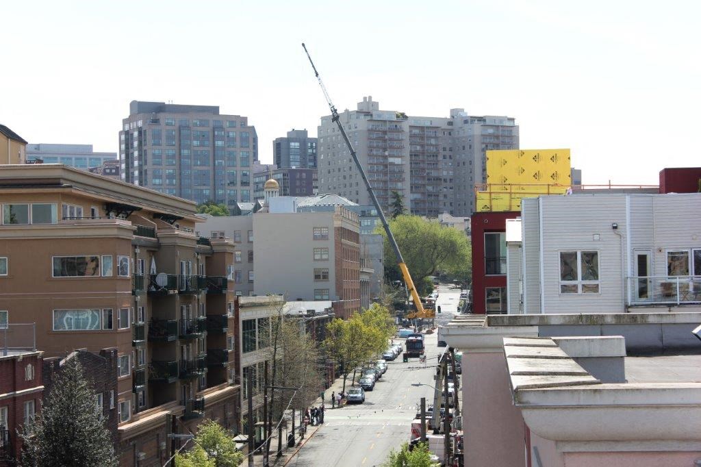 a view of a city street with buildings and a crane