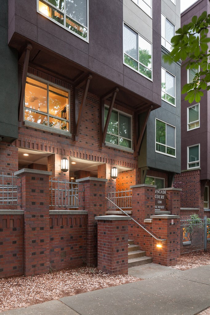 a view of the front of a brick building with windows and a staircase