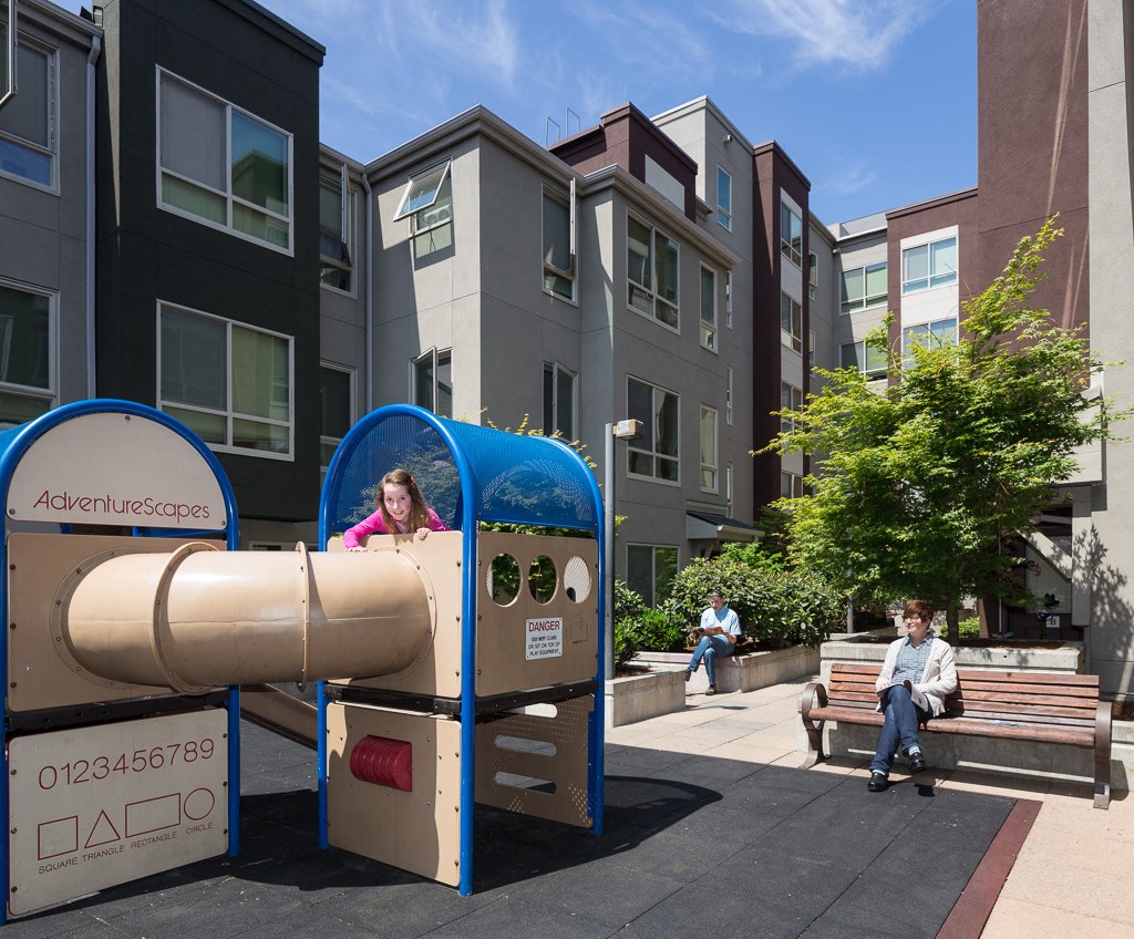 a little girl in a mailbox on a city street