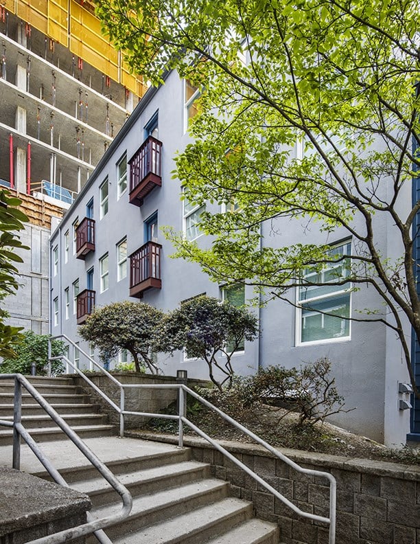 a staircase leading up to a building with trees in front of it