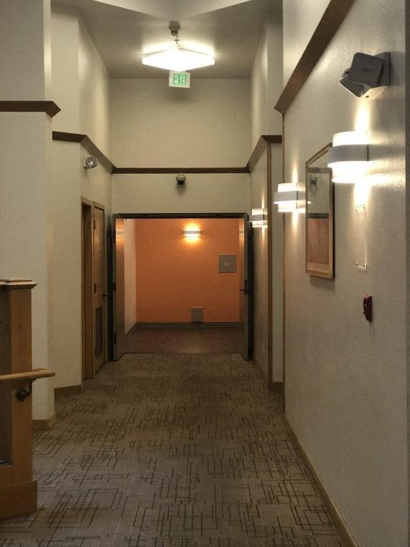 a hallway with a door to a room with an exit sign