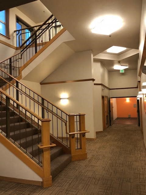 a lobby with a staircase and a hallway with stairs