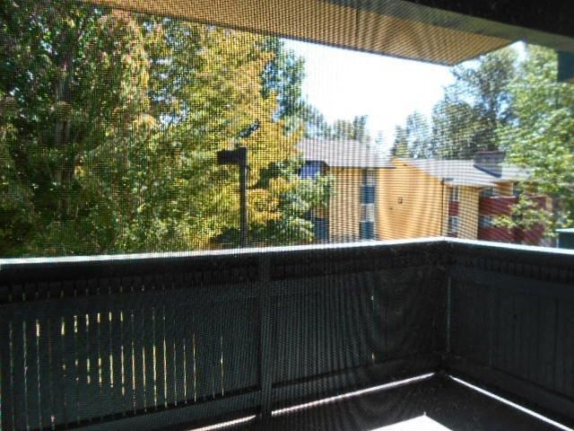 a balcony with a view of a house and trees
