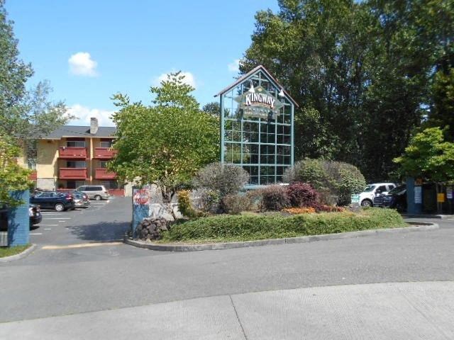 a parking lot with a glass building and trees